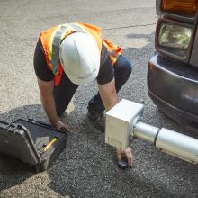 worker inspecting asphalt