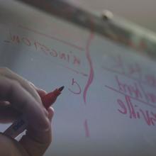 Men writing on a white board