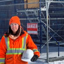 Kasandra Gauthier, Materials technician, close up standing outside holding hard hat