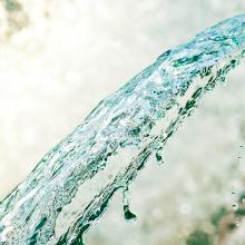 Close up image of water falling from a drain