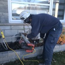 Englobe employee installing radon testing equipment