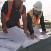 a group of three men reviewing building plans