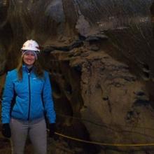 Photo of Lydia Charbonneau underground with her white helmet and blue jacket