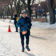 Mathieu Béland running on a snow‑covered path during the Snow Pentathlon, wearing winter athletic gear with race bib 667 visible.